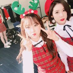 two young women dressed up in christmas themed outfits posing for the camera with reindeer ears and antlers on their heads