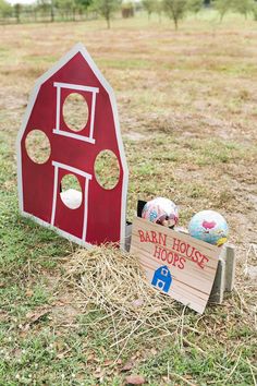 a red barn house with holes in the roof and two balls on top of it