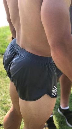 the back of a man's shorts with no shirt on, standing in grass