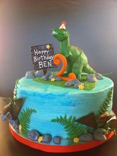 a birthday cake with a dinosaur on top