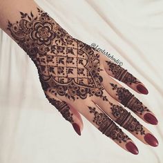 a woman's hand with henna tattoos on it