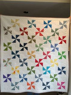 a colorful quilt hanging on the wall