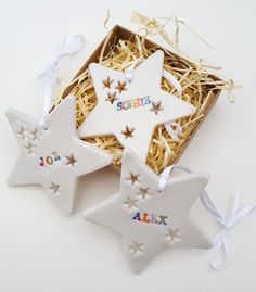 three ceramic stars in a gift box with ribbon around the edges that spell out name