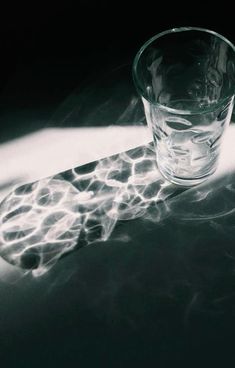 a glass sitting on top of a table covered in water