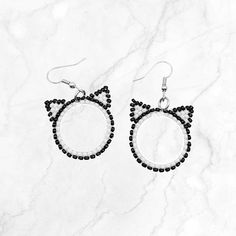 These simple but adorable hoop earrings are the perfect accessory for any cat enthusiast. These dangly hoop earrings with cute cat ears are a great way to share your love for cats in a playful, stylish way.  Details: Earrings are carefully handcrafted with attention to detail. Each miyuki glass seed bead is handwoven one at a time with sturdy nylon thread. As each piece is 100% handmade, they are unique and may have slight variations in pattern, colors, and sizing. Color: - Black and white beads Beaded Cat Earrings, Earrings Animals, Beaded Cat, Store Earrings, Handmade Beaded Earrings, Cloth Pads, Handmade Earrings Beaded, Cat Silhouette, Earrings Beaded