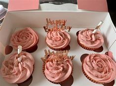 six cupcakes with pink frosting and candles in a white box that says happy birthday