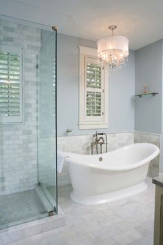 a white bath tub sitting inside of a bathroom next to a walk - in shower