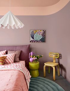 a bed room with a neatly made bed next to a small table and two chairs