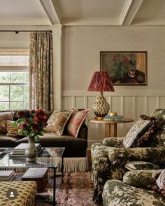 a living room filled with furniture and a painting on the wall above it's windows