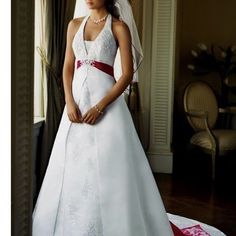 a woman in a white wedding dress standing next to a window with her hands on her hips