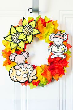 a paper plate wreath decorated with fall leaves and an image of a mouse on it