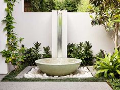 an outdoor fountain surrounded by plants and rocks