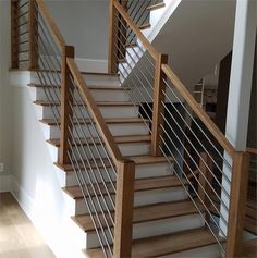 there is a stair case in the middle of an empty room with wood and metal railings