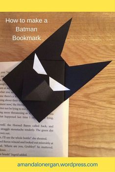 an origami cat reading a book with the title how to make a batman bookmark