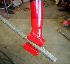 a red fire hydrant sitting on top of a floor next to a pile of tools