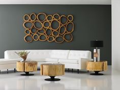 a modern living room with white furniture and wood circles on the wall above it's coffee table