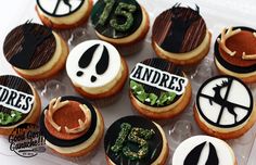 an assortment of decorated cupcakes on display in a plastic container