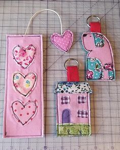 three pieces of fabric with hearts and houses on them next to a sewing machine ruler