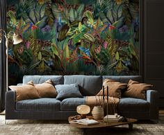 a living room with a blue couch and wallpaper that has tropical leaves on it