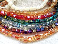 multicolored glass beads are lined up on a white surface