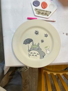 a plate with an image of a totoro on it sitting on a table