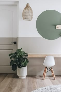 there is a potted plant next to a white chair in the corner of this room