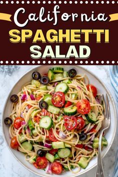 a white bowl filled with spaghetti salad and topped with cucumbers, tomatoes, olives