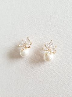 two pairs of pearl and crystal earrings on a white surface with the word love written in gold