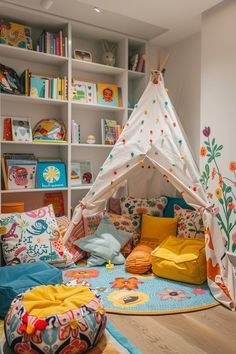 a child's room with a teepee tent, pillows and bookshelves