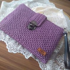 a purple crocheted purse sitting on top of a white doily