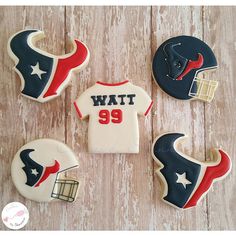 cookies decorated to look like football uniforms and helmets are arranged on a wooden table top