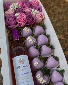 a bottle of wine and some chocolates in a white box with flowers on it