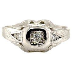 an antique style diamond ring with filigrees on the sides and two diamonds in the center