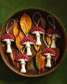 mushrooms and leaves in a wooden bowl on a green surface