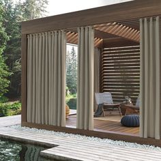 an outdoor living area with sliding glass doors and wooden decking next to the pool