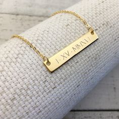 a gold bar necklace with the word i am on it