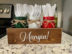 mason jars and utensils are sitting in a wooden sign that says, mango