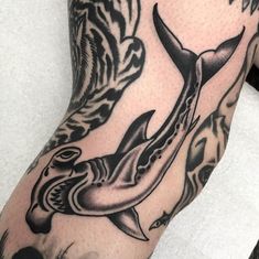 a man's arm with tattoos on it and an image of a shark in the water