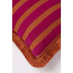 an orange and pink striped pillow with fringes