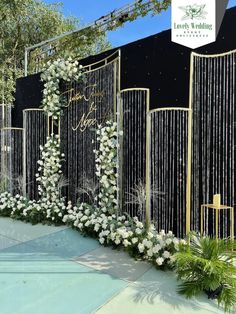 an outdoor wedding ceremony setup with flowers and greenery on the side of the stage