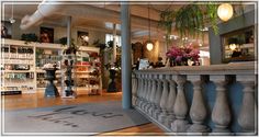 the inside of a store with lots of shelves and vases on top of it