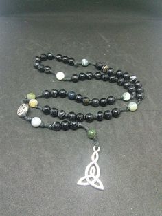 This is a beautiful re-imagined rosary based on the classic Catholic rosary. The beads are evil eye agate and fancy jasper. There are five decades of nine beads each. The center is a Celtic knot, and I have capped it off with a triad pendent. With this rosary I'm including a simple chant which has resonated with me, but feel free to use your own! Pagan/witch prayer chant: Knot one, the work's begun. Knot two, my aim is true. Knot three, it will be. Knot four, power's stored. Knot five, the work' Spiritual Onyx Beads Jewelry 8mm, Spiritual Gemstone Beads Rosary, Spiritual Rosary Bracelet With Natural Stones For Meditation, Spiritual Rosary With 8mm Beads, Spiritual Rosary Bracelet With Round Beads For Meditation, Spiritual Rosary With 8mm Beads For Healing, Spiritual Rosary Bracelet With Round Beads For Healing, Spiritual Healing Rosary Bracelet With Round Beads, Adjustable Spiritual Rosary Bracelet With 108 Beads