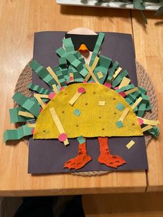 a turkey made out of construction paper sitting on top of a table