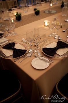 the table is set with silverware and black napkins