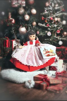 a doll sitting in front of a christmas tree