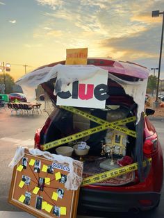 the back of a red car that has been wrapped in tape and taped with yellow caution tape