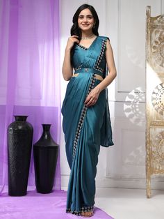 This stunning teal blue satin saree features intricate lace work that adds a touch of elegance to your look. The matching blouse in the same fabric and lace detailing completes the set perfectly.
The designer belt with stonework adds a glamorous touch to the outfit. This ready-to-wear saree and blouse set comes in sizes S to L, making it easy for you to find the perfect fit.
The 5.50 meters of fabric is pre-stitched for your convenience, so you can simply drape it on and look effortlessly chic.
Wear this saree to parties, receptions, or any special occasion to make a fashion statement and turn heads wherever you go. Designed for comfort and style, this saree is a must-have in your ethnic wear collection. Saree And Blouse