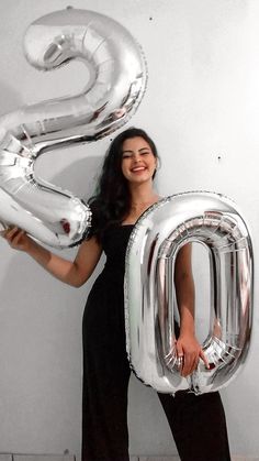 a woman holding up the number two balloon