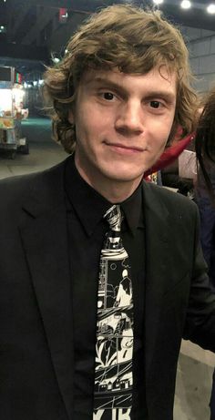 a young man in a black suit and tie