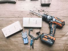 the tools are laying out on the wooden floor next to the box and screwdriver